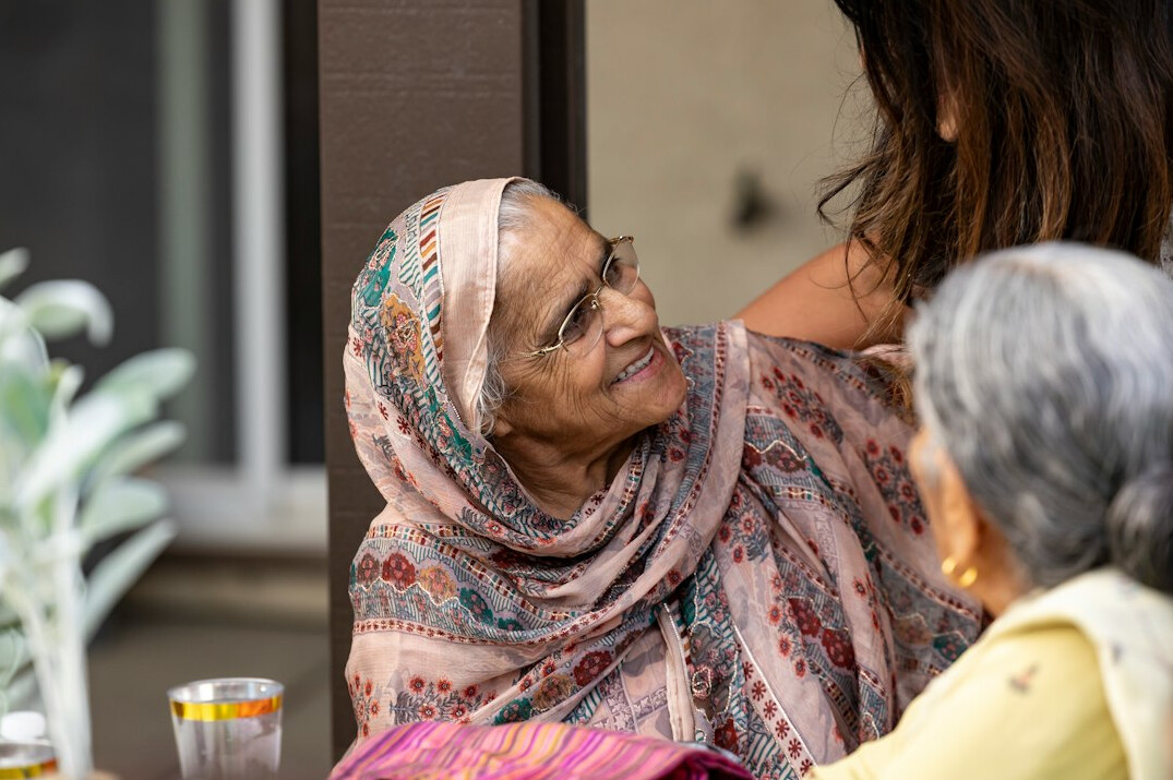 Group of smiling senior friends sitting together at a community center table