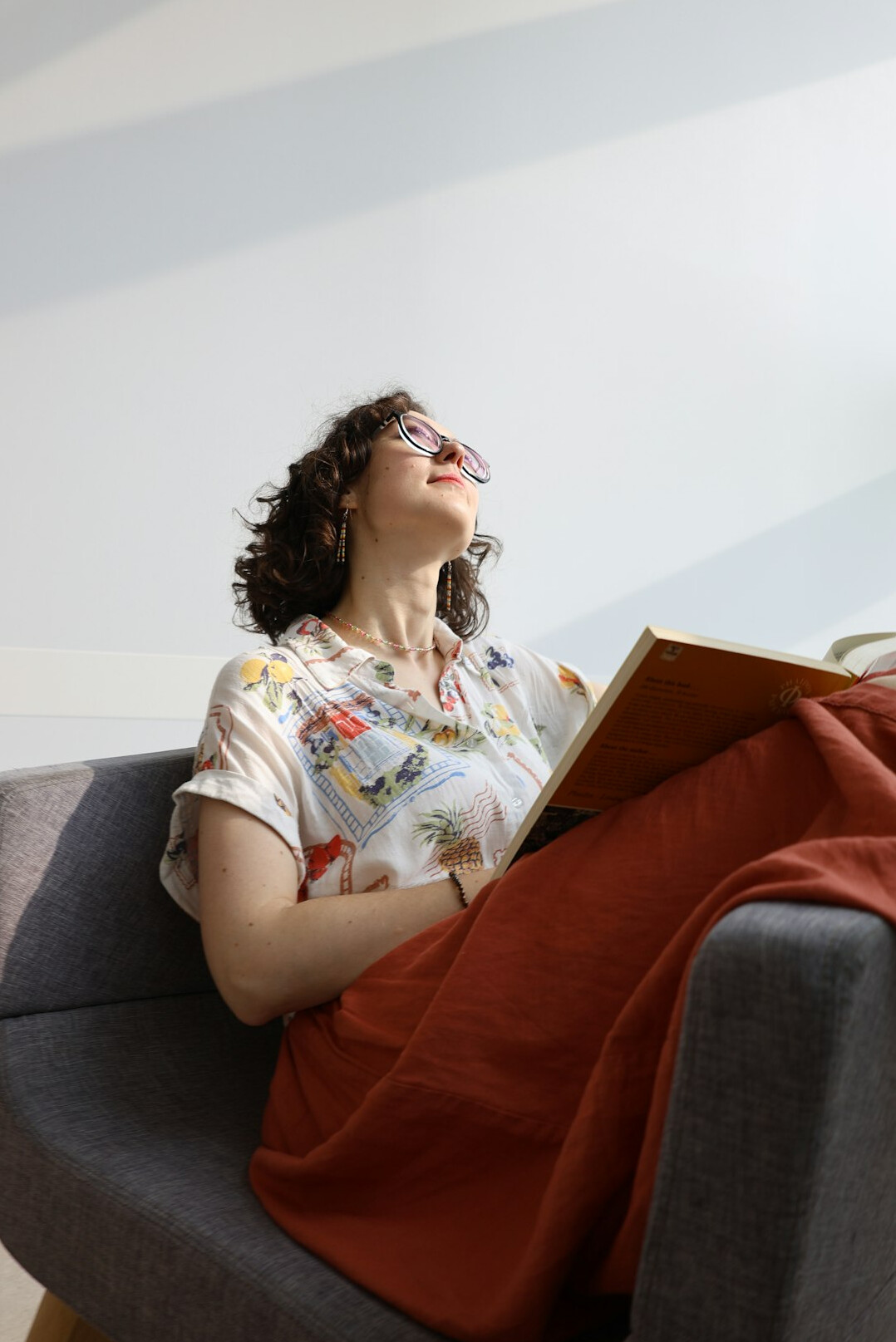 Senior woman reading a book while sitting comfortably in an armchair