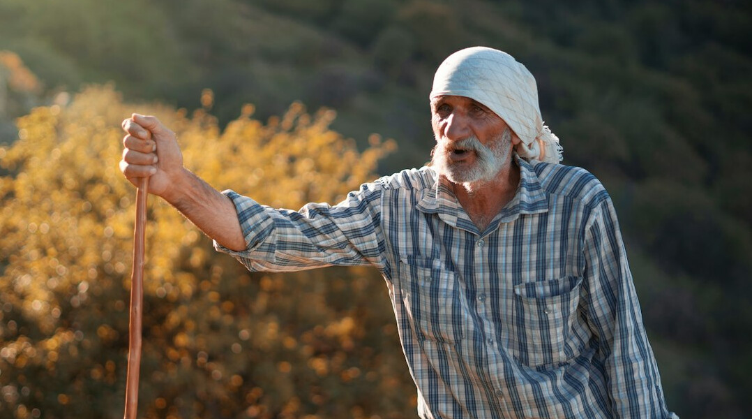 Senior man tending to plants in a community garden